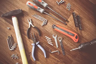 Werkzeug auf einem Holztisch: Hammer, Zangen, Schraubendreher
