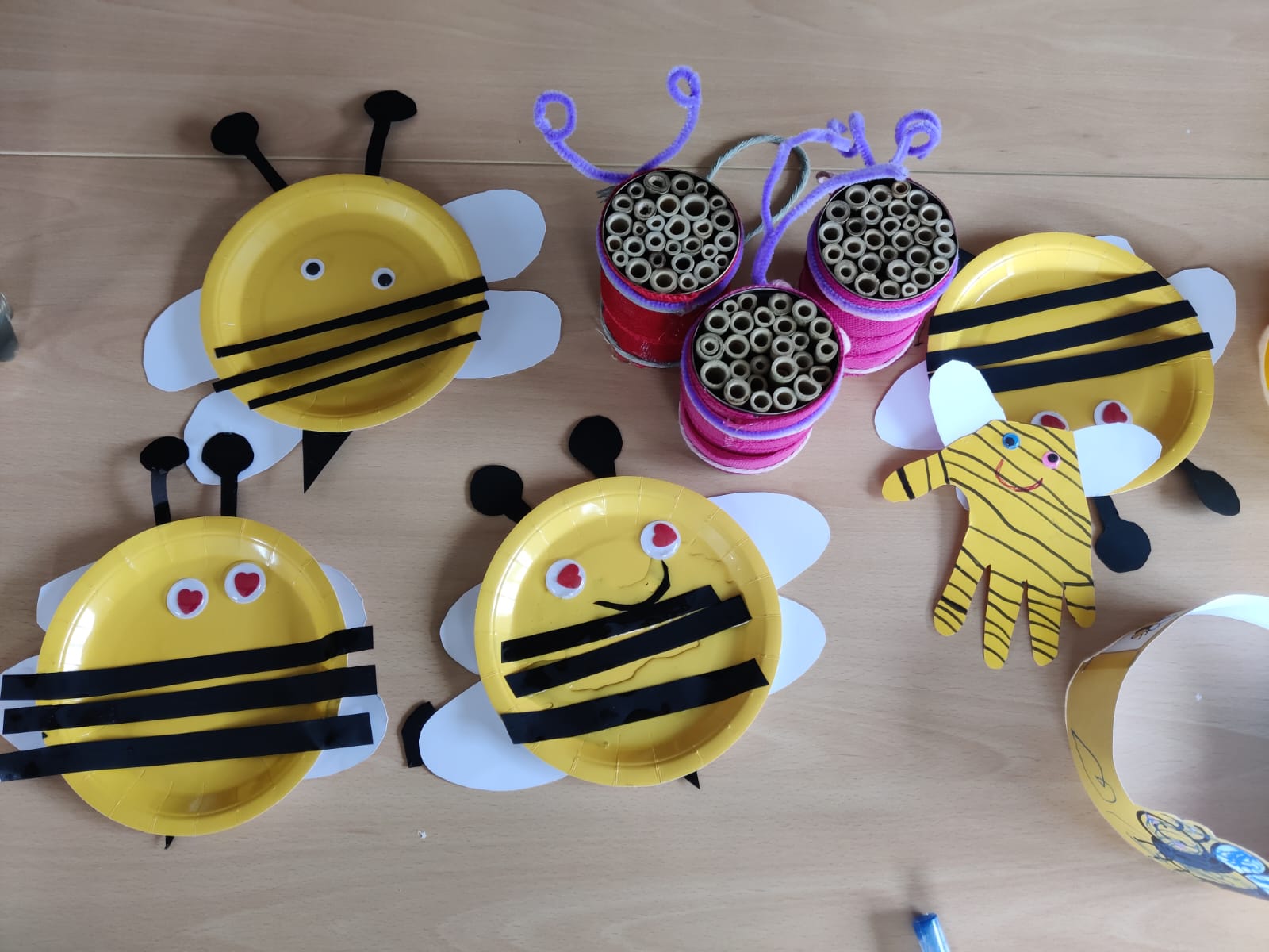 Aus Papptellern gebastelte Bienen mit schwarzen Streifen und weißen Flügeln