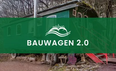 Grün gestrichener Bauwagen am Waldrand mit roter Holztreppe
